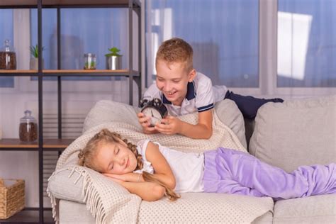 Premium Photo Brother Wakes Up Sister With Alarm Clock Calls Loudly And Does Not Want To Get