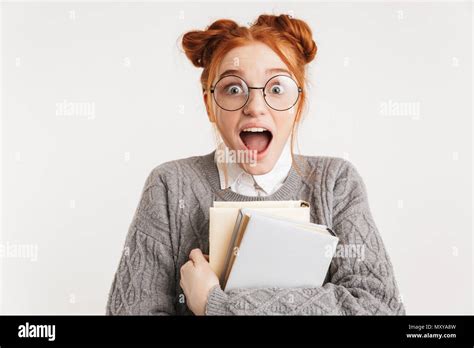 Portrait Of A Surprised Young School Nerd Girl Holding Stack Of Books