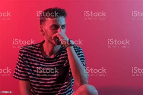 Young Handsome Man Sitting On Chair By Neon Lights Stock Photo
