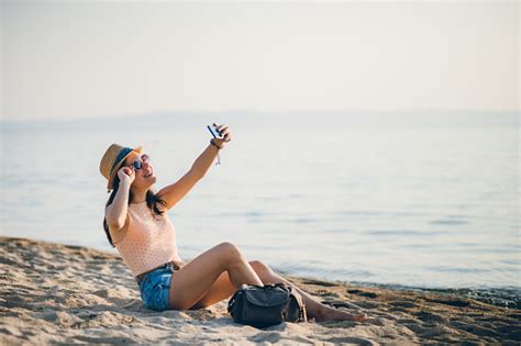frau am strand macht selfies stockfoto und mehr bilder von am telefon am telefon attraktive
