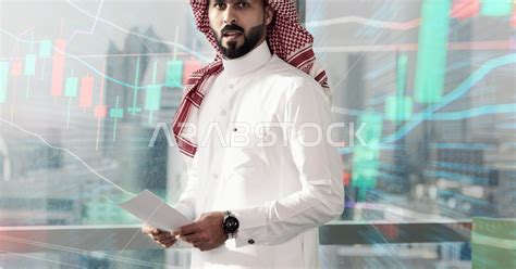 رجل اعمال عربي سعودي خليجي في مقر العمل رسومات هولوجراميه توضح نسبة انجاز الاعمال متابعة سوق