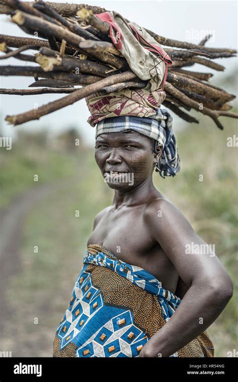 portrait of a woman from the holi tribe carrying a load on her head in africa many things are