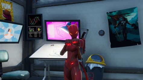A Red Robot Standing In Front Of A Computer Monitor And Desk With