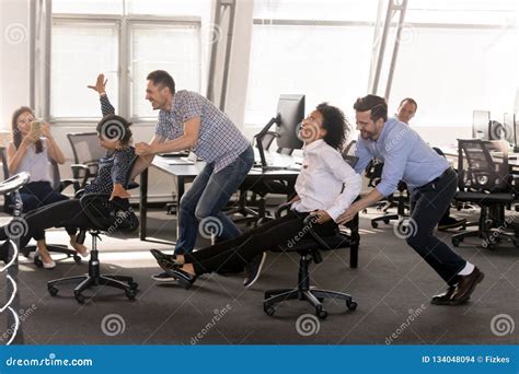 Excited Diverse Employees Having Fun Together In Office Stock Photo