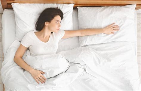 Depressed Young Woman Lying In Bed And Feeling Upset Stock Photo