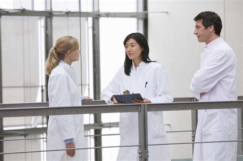 Group Of Scientists Holding Meeting In Atrium Stock Photo