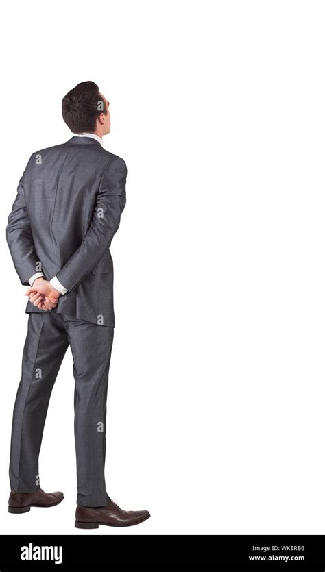 Businessman Standing With Hands Behind Back On White Background Stock