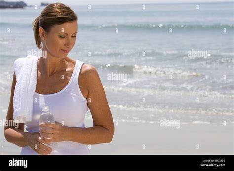 Woman Holding Bottle Of Water At The Beach Stock Photo Alamy