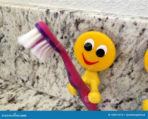 Fun Yellow Emoji Smiling Toothbrush Holders For Kids Stock Photo