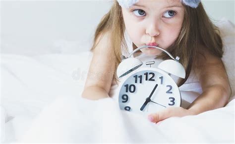 Little Girl Wakes Up In Morning Under White Blanket Wearing Grey Bunny