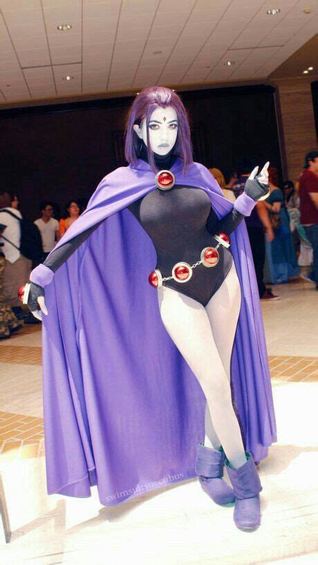 A Woman In A Purple Cape And Black Bodysuit With Red Buttons On Her Chest