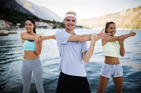 Group Of Happy Friends Or Sportsmen Exercising And Stretching Outdoor