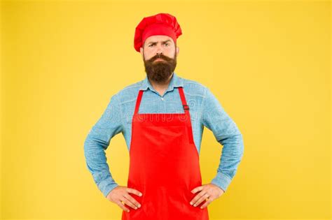 Un Chef Serio Con Barba Y Delantal Rojo Sostiene Un Alfiler De Madera