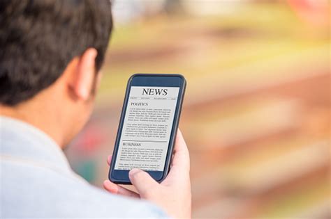 News Article Concept On Phone Screen Man Holding Smartphone Reading News Article On Screen Stock