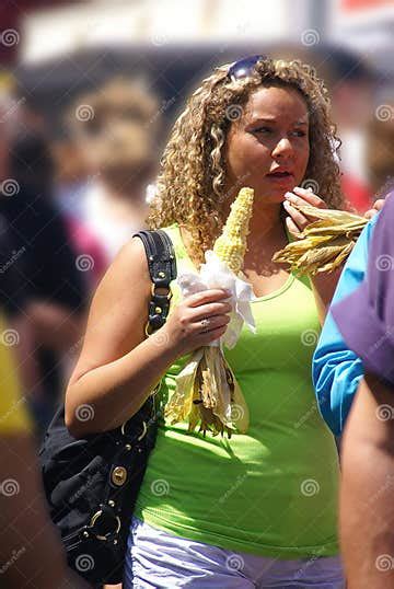 Young Blonde Woman In Green Eating Corn On The Cob Editorial