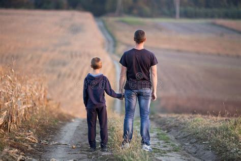 Padre E Hijo Que Caminan Juntas Llevando A Cabo Las Manos Imagen De