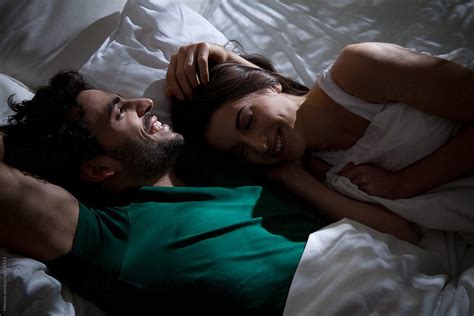 Young Couple Talking And Laughing In Bed Before Sleep By Stocksy Contributor Mosuno Stocksy