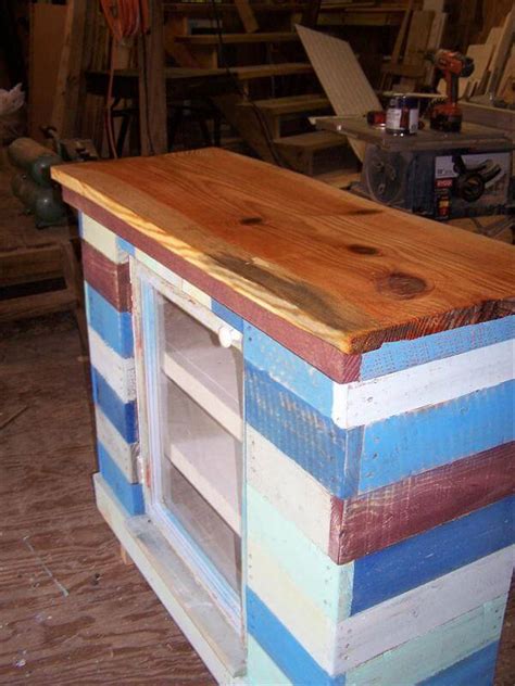 Entire wooden base is having installed cabinets that really make it easier to store the kitchenware and kitchen clutter if any! DIY Pallet and Old Window Cabinet - Sideboard! | 101 Pallets