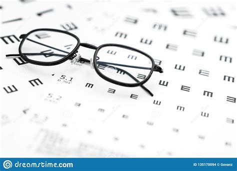 Eyeglasses And Visual Acuity Chart In White Background Stock Photo