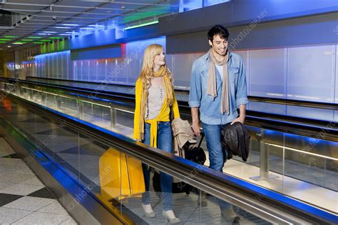 A person walks at a steady pace of 3 m/s. Couple on moving walkway in airport - Stock Image - F018 ...