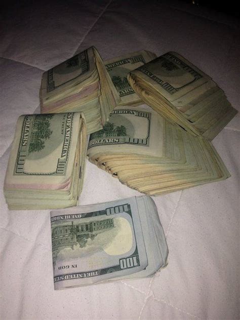Several Stacks Of One Hundred Dollar Bills Laid Out On Top Of A White Bed Sheet