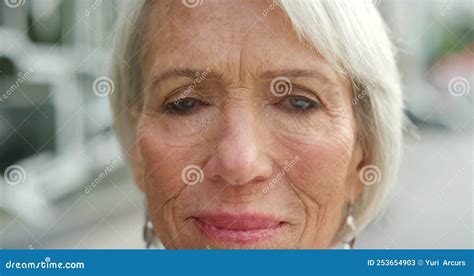 Closeup Portrait Of A Mature Woman Face Against A Blurry Urban
