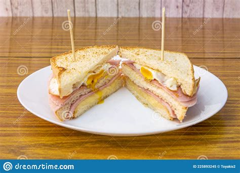Double Decker Sandwich For Breakfast Or A Snack With A Fried Egg Several Slices Of Ham And