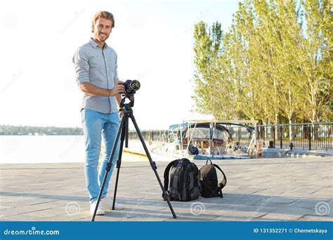 Young Male Photographer Standing With Professional Camera Stock Image