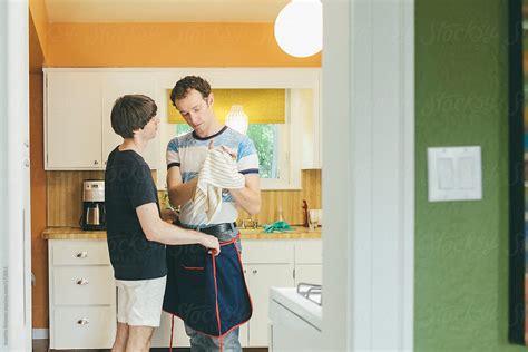 Gay Men Couple Talking After Doing Chore Of Washing Dishes In Kitchen By Stocksy Contributor