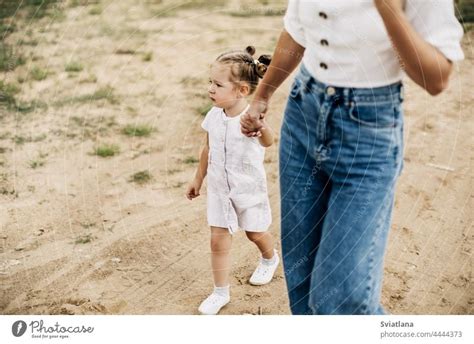 Mom And Her Little Daughter Are Walking Holding Hands Spending Time Together A Royalty Free