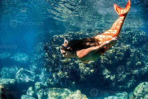 Mermaid Swimming Underwater In The Deep Blue Sea 12205388 Stock Photo