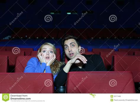 How Much Is It To Watch A Movie - Man And Woman Watch Movie And Very Much Afraid In Movie Theater. Stock