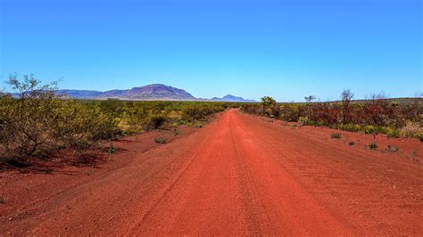 Outback Red Dirt Road Leading To Mountain And Blue Sky Photograph By