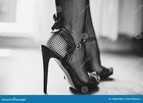 Woman Legs In High Heel Sandals Fishnet Stockings With Black Bow Stock