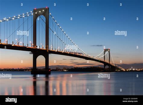 The Bronx Whitestone Bridge Reflecting On The East River At Night In