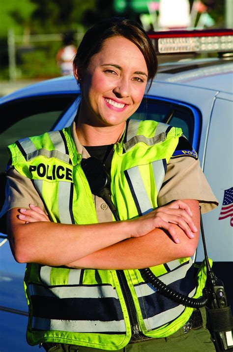 a female police officer smiling as she crosses her arms police chief magazine