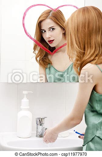 Redhead Girl Near Mirror With Heart It In Bathroom