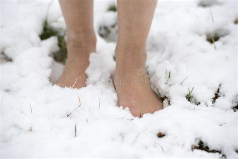 Selective Focus Shot Of A Person In Bare Feet Standing On A Snowy