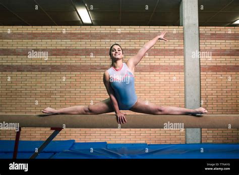 Full Length Of Female Gymnast With Legs Apart Exercising On Balance