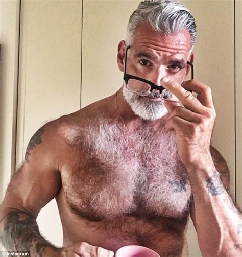 An Older Man With Grey Hair Is Brushing His Teeth And Holding A Pink