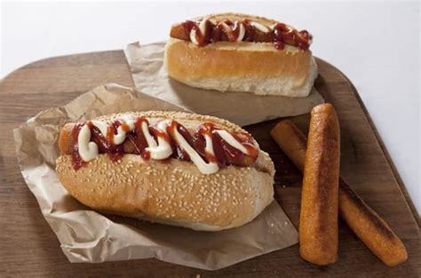 Two Hot Dogs On Buns With Ketchup And Mayonnaise Drizzled On Them