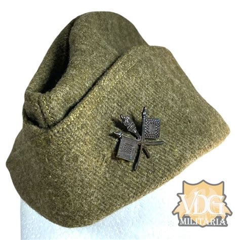 A Close Up Of A Hat With A Pin On The Front And Side Of It