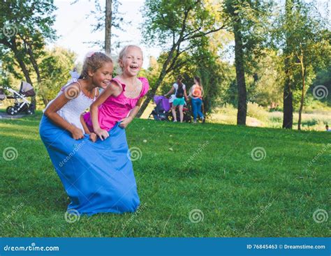 Girls Compete In A Relay Race Jumping In Bags They Laugh And Fall