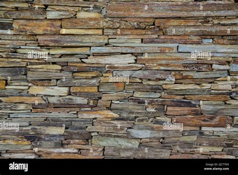 Stone Wall Made Of Multi Colored Layered Natural Sandstone Stock Photo
