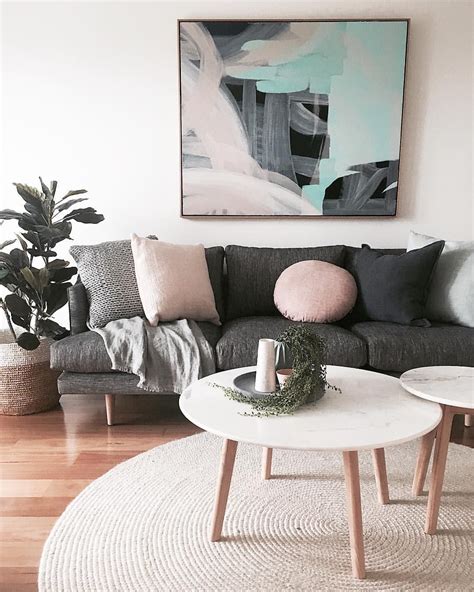 Living room | Dark grey lounge, pink cushions, artwork, wood | Grey