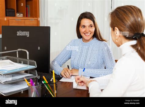Mature Woman Answering Questions Of Employee At Office Stock Photo Alamy