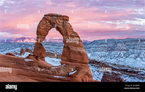 A Colorful Sunset Lights Up The La Sal Mountains Behind Iconic Delicate