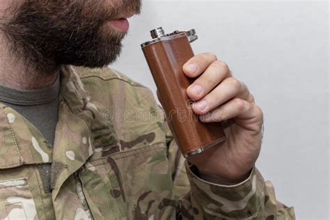 A Soldier In Military Uniform Brings A Flask To His Mouth Concept