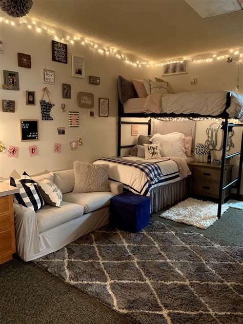 A Dorm Room With Bunk Beds Couches And Lights On The Wall Above It