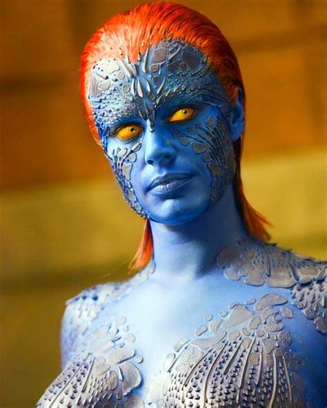 A Close Up Of A Person With Blue Paint On Their Body And Orange Hair